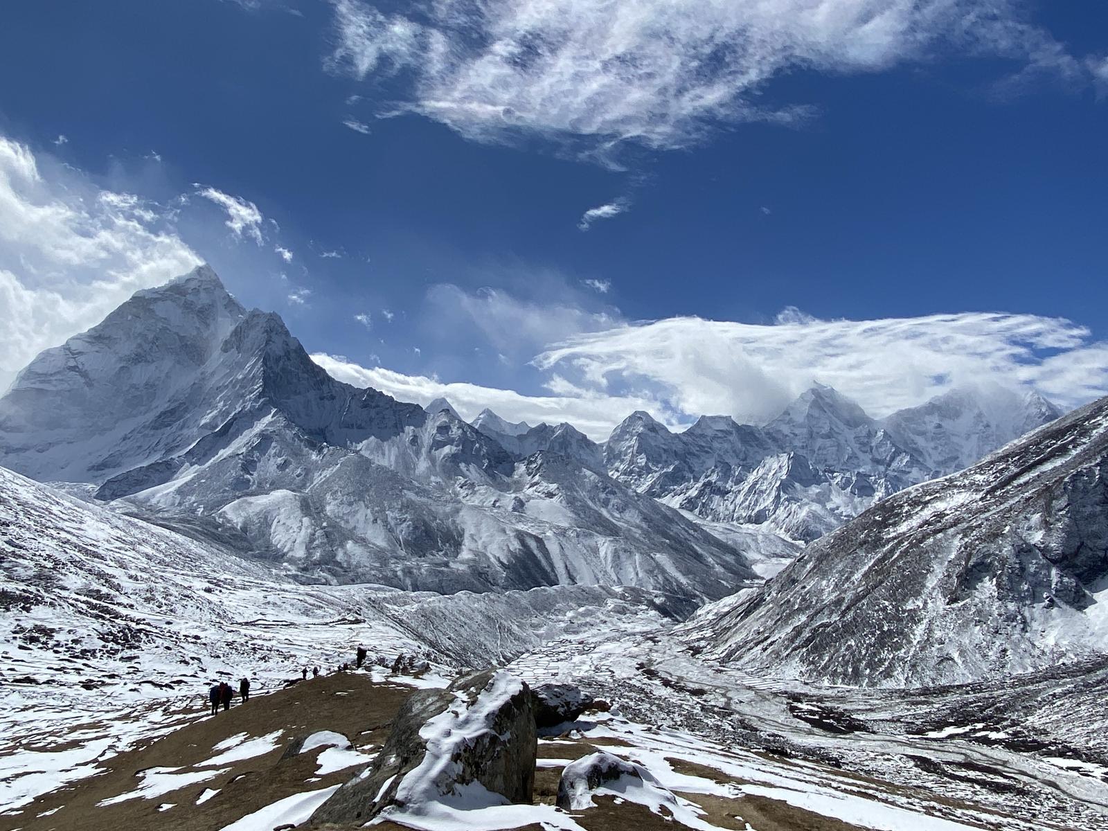 Snowy mountain landscape with a clear blue sky, walking trail to everest.